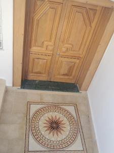 a wooden door with a rug in front of it at MAISON SIDI BOU SAID in Hammamet