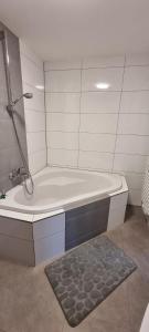 a white bathroom with a shower and a tub at Ferienwohnung Sigmarino in Sigmaringen