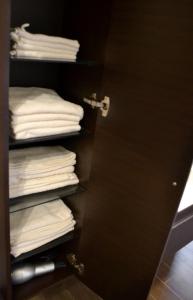 a closet with a stack of folded towels at la Dolce Vita - Appartamento con parcheggio privato vicino al centro e all'ospedale in Asti