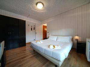 a bedroom with a large bed with white sheets at Hotel Arlecchino - Dada Hotels in Madesimo