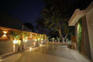 un patio con luces en una valla por la noche en The Cozy Chaos, en Agra