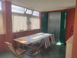 uma cozinha com uma mesa e duas cadeiras e uma janela em Villa Crescenza em Mola di Bari