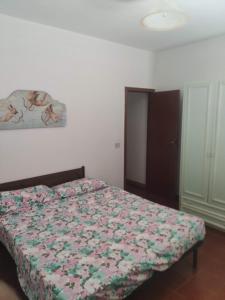 een slaapkamer met een bed met een bloemdekbed bij Villa Crescenza in Mola di Bari