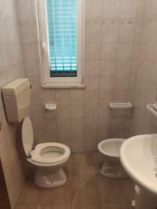 uma casa de banho com um WC, um lavatório e uma janela em Villa Crescenza em Mola di Bari