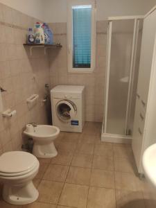 een badkamer met een toilet en een wasmachine bij Villa Crescenza in Mola di Bari
