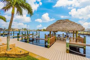 ein Pier mit einer Strohhütte auf dem Wasser in der Unterkunft Bikini Bottom in Cape Coral