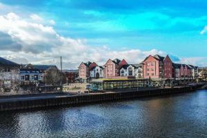 a row of houses next to a river at Cosy home with parking close to city centre in Exeter