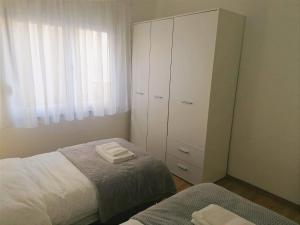 Široki Brijeg的住宿－Apartman STAR，一间卧室配有一张床,一个配有两条毛巾的橱柜