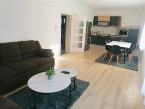 ein Wohnzimmer mit Sofa und Tischen und eine Küche in der Unterkunft Apartman STAR in Široki Brijeg