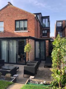 a patio with black furniture in front of a brick building at Stunning Modern Large 5 Bed House Willesden in London