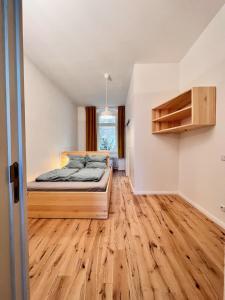 a bedroom with a bed and a wooden floor at Central apartment in trendy Friedrichshain in Berlin
