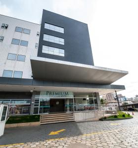 um grande edifício com uma placa que lê o pentium em Premium Executive Hotel Itabira em Itabira