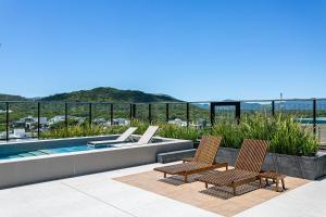 - deux chaises et une piscine au-dessus d'un bâtiment dans l'établissement WI-FI 300MB | Rooftop com Piscina em Jurerê #JA15, à Florianópolis
