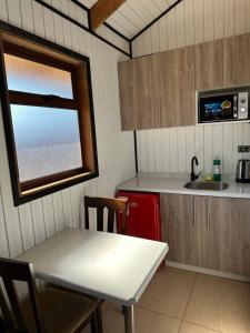 una pequeña cocina con mesa y fregadero en Complejo Turístico Los Laureles Arauco, en Arauco