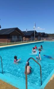 un grupo de niños jugando en una piscina en Complejo Turístico Los Laureles Arauco, en Arauco