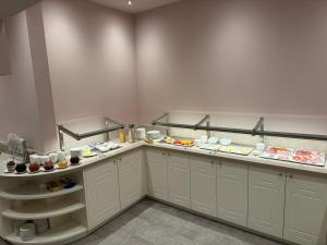 a kitchen with white cabinets and plates of food at Privat-Hotel Villa Aurora in Bad Neuenahr-Ahrweiler