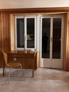 a desk and a chair in a room with a window at App 2-3 p Lake View Vallée de Joux in Le Pont