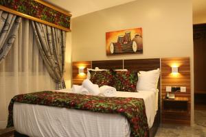 Saire Hotels Ibadan في إيبادان: غرفة نوم بسرير كبير مع ديكورات عيد الميلاد
