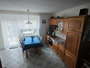 een keuken met een tafel met een blauwe tafeldoek bij Ferienwohnung Hidde in Ostseebad Koserow