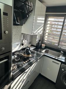 a kitchen with a stove top oven next to a sink at Appartement spacieux, très calme in Casablanca