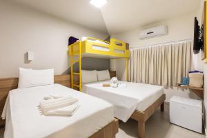 a room with two beds and a bunk bed at Tarobá Express in Foz do Iguaçu
