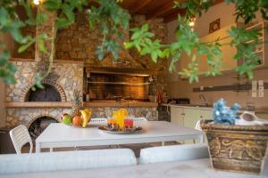 a kitchen with a table and a stone oven at Chillax House Near The Sea by Athenian Keys in Káto Alepokhórion