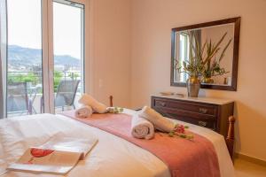 a bedroom with a bed with a mirror and a window at Chillax House Near The Sea by Athenian Keys in Káto Alepokhórion