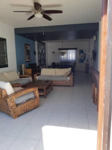 uma sala de estar com mobiliário em vime e uma ventoinha de tecto em Golf Course View & Totally Private Pool em Nuevo Vallarta 