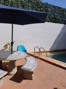 um pátio com uma mesa, um guarda-sol e cadeiras em Golf Course View & Totally Private Pool em Nuevo Vallarta 