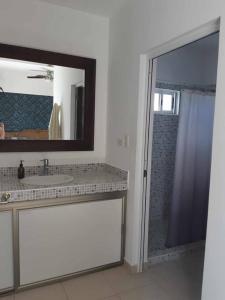 uma casa de banho com um lavatório, um espelho e um chuveiro em Golf Course View & Totally Private Pool em Nuevo Vallarta 