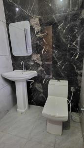 a bathroom with a white toilet and a sink at Hotel Panipat Town House in Pānīpat +10 photos