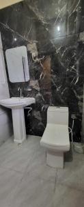 y baño con aseo blanco y lavamanos. en Hotel Panipat Town House, en Pānīpat