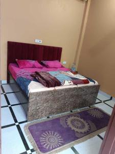 Cama en habitación con 2 alfombras en el suelo en Hotel Panipat Town House, en Pānīpat