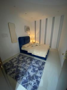 ein kleines Schlafzimmer mit einem Bett und einem blauen Stuhl in der Unterkunft ريحانه in Şabyā