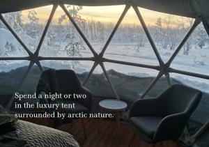 a room with a window with a chair and a view at Arctic Nature Experience Glamping in Vuontisjärvi