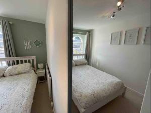 a small bedroom with two beds and a mirror at Lancaster 1 bed Cottage Apartment- M6 - Lancs Uni in Lancaster