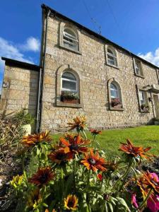 a stone building with flowers in front of it at Lancaster 1 bed Cottage Apartment- M6 - Lancs Uni in Lancaster
