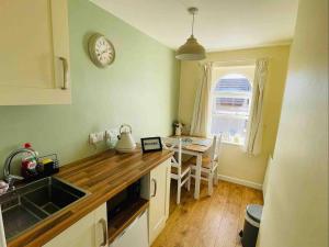 a kitchen with a table and a clock on the wall at Lancaster 1 bed Cottage Apartment- M6 - Lancs Uni in Lancaster