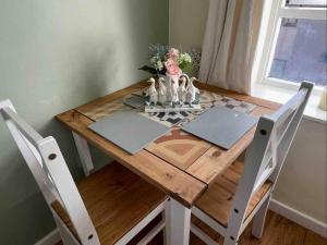 a wooden table with a vase of flowers on it at Lancaster 1 bed Cottage Apartment- M6 - Lancs Uni in Lancaster
