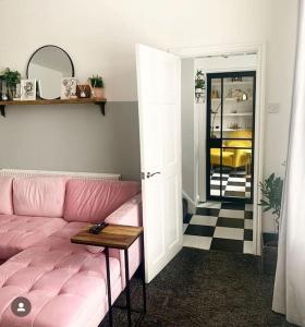 ein Wohnzimmer mit einem rosa Sofa und einem Tisch in der Unterkunft The Tiled Terrace in Liverpool
