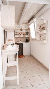 una cucina bianca con tavolo bianco in una stanza di Karen House B&B a Polignano a Mare