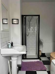 ein weißes Bad mit einem Waschbecken und einer Dusche in der Unterkunft The Tiled Terrace in Liverpool