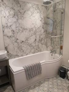 a white bath tub in a bathroom with a shower at Owl's Hoot in Snettisham