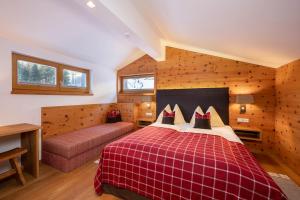 a bedroom with a red bed and a couch at Sonnenseite Filzmoos in Filzmoos +152 photos