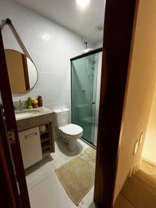 a bathroom with a toilet and a glass shower at Village 3/4 a 140m da praia in Ilhéus