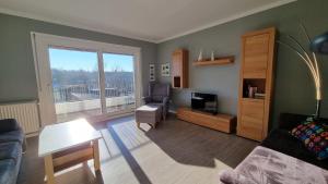 a living room with a couch a chair and a television at Haus Spökenkieker in Borkum