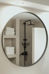 a bathroom mirror with a shower with towels at Thalpo home in Ioannina