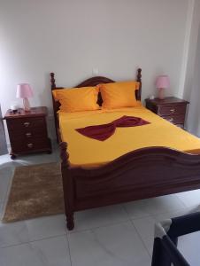 - une chambre avec un lit avec des draps jaunes et 2 tables dans l'établissement Bentub home, à Ribeira Grande