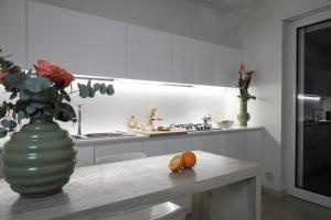a kitchen with a vase and a table with an orange on it at Dimora Pacelli in Castellana Grotte