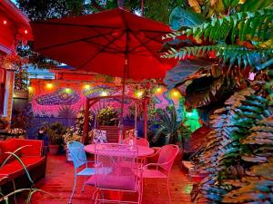 einen Tisch mit Stühlen und einen Sonnenschirm in einem Garten in der Unterkunft The Blue60 Marigny Inn in New Orleans